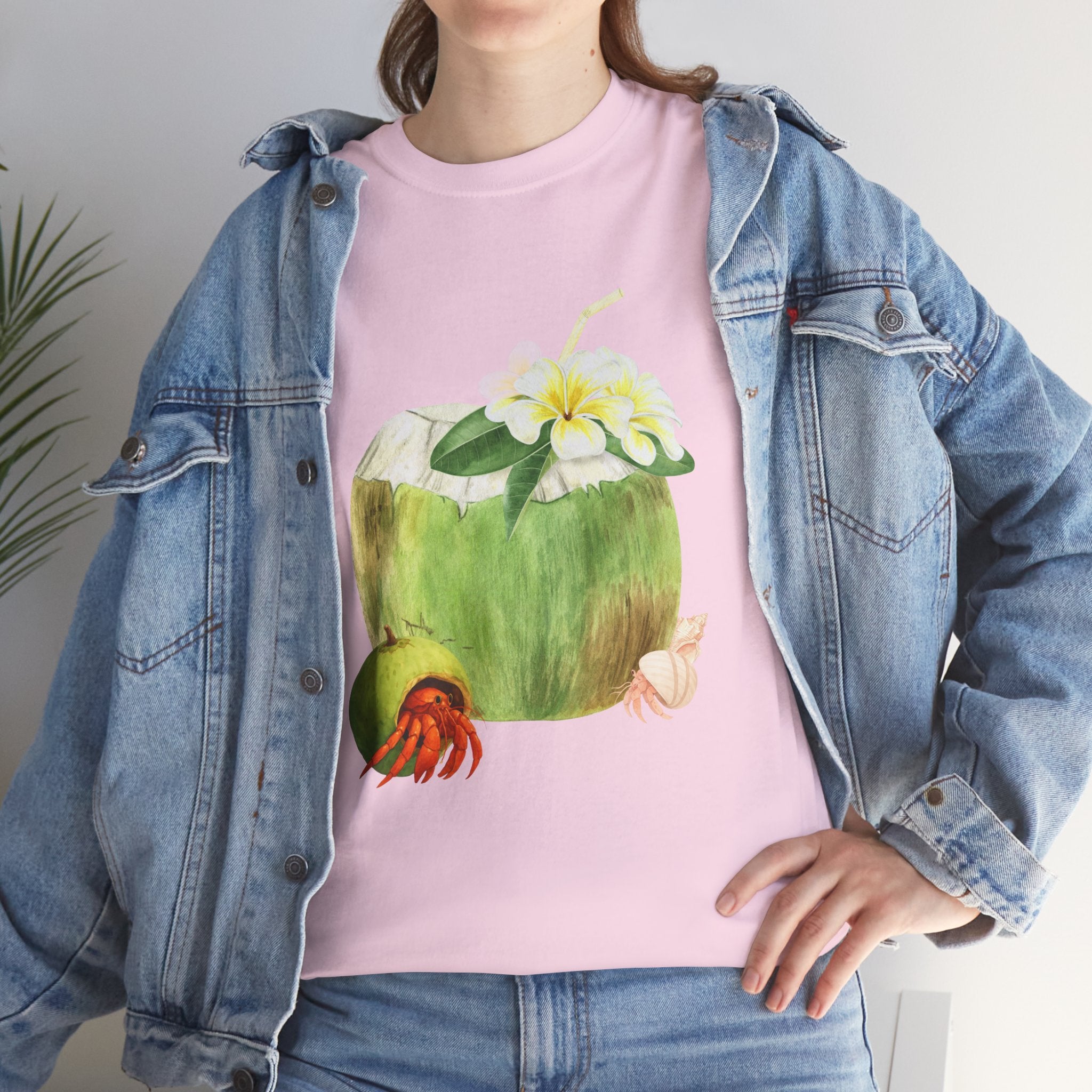 A girl wearing a denim jacket over a pink t-shirt featuring a colorful design of a hermit crab in a coconut shell and a straw-topped coconut.