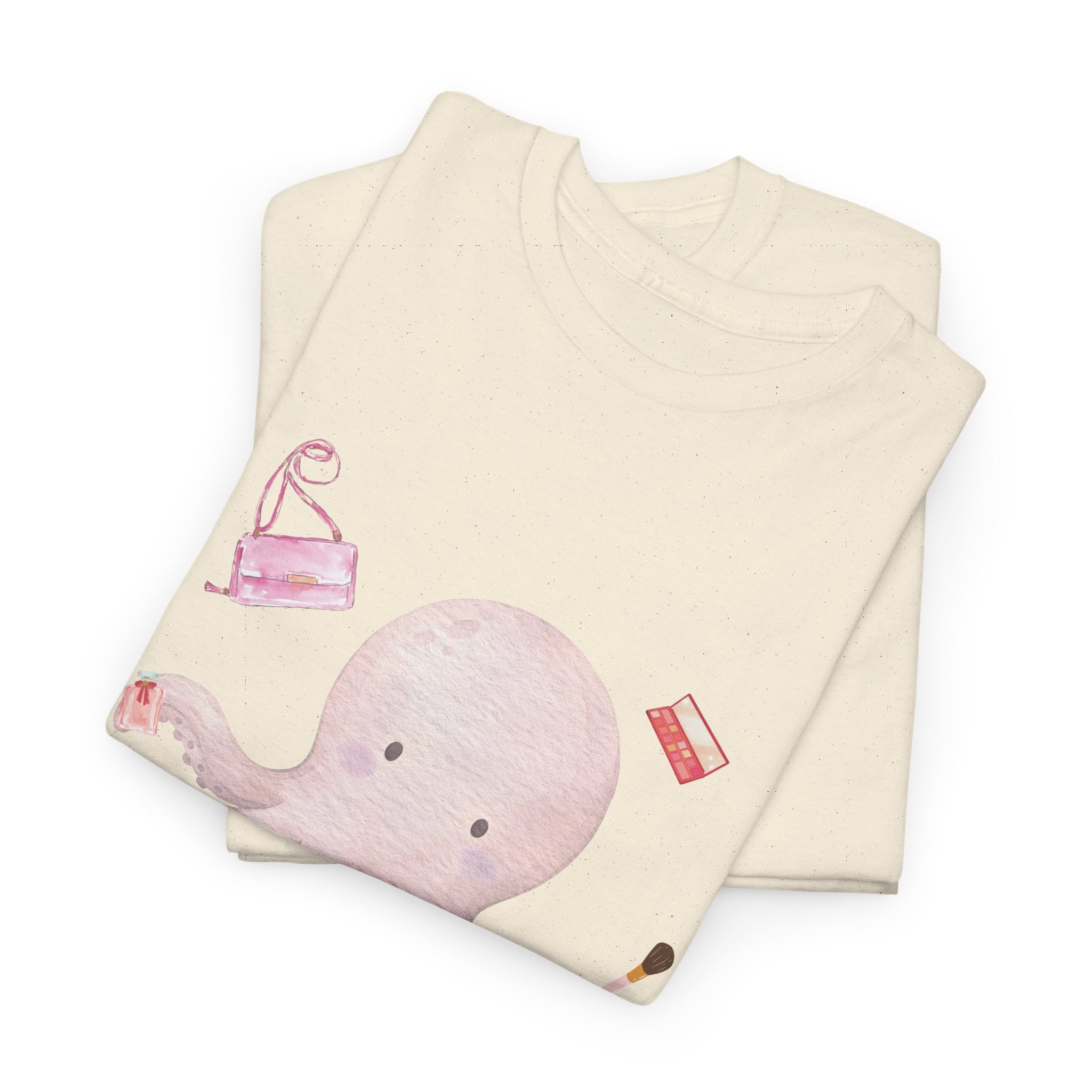 A folded beige t-shirt featuring a graphic design of a pink octopus multitasking its tentacles to apply lipstick, brush on makeup, and juggle beauty accessories.