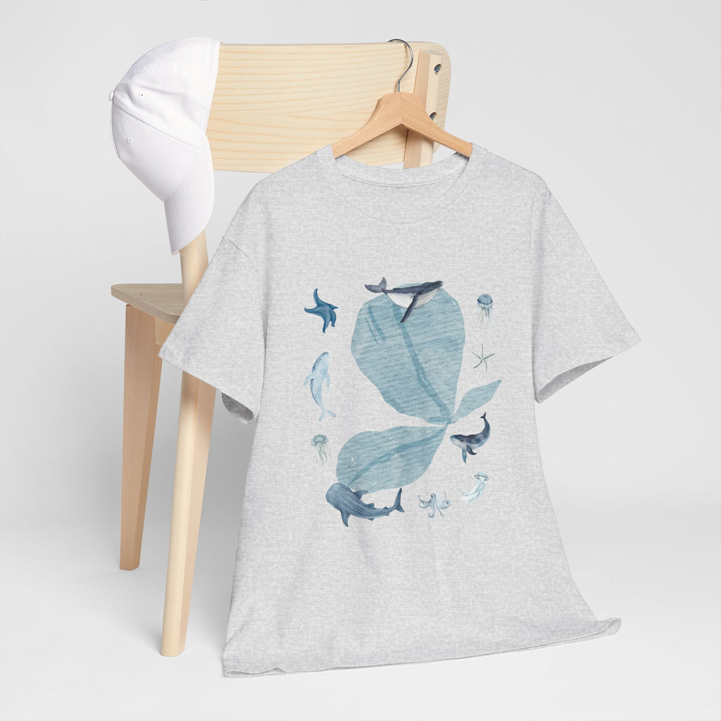 A grey t-shirt hanging on a chair, featuring a graphic design of a blue bloom surrounded by whales, jellyfish, and starfish.