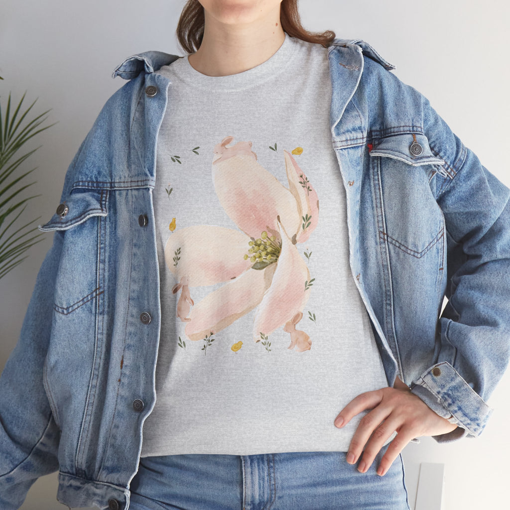 A girl wearing a denim jacket over a grey t-shirt featuring a colorful design of a pink bloom surrounded by bunnies in various poses.