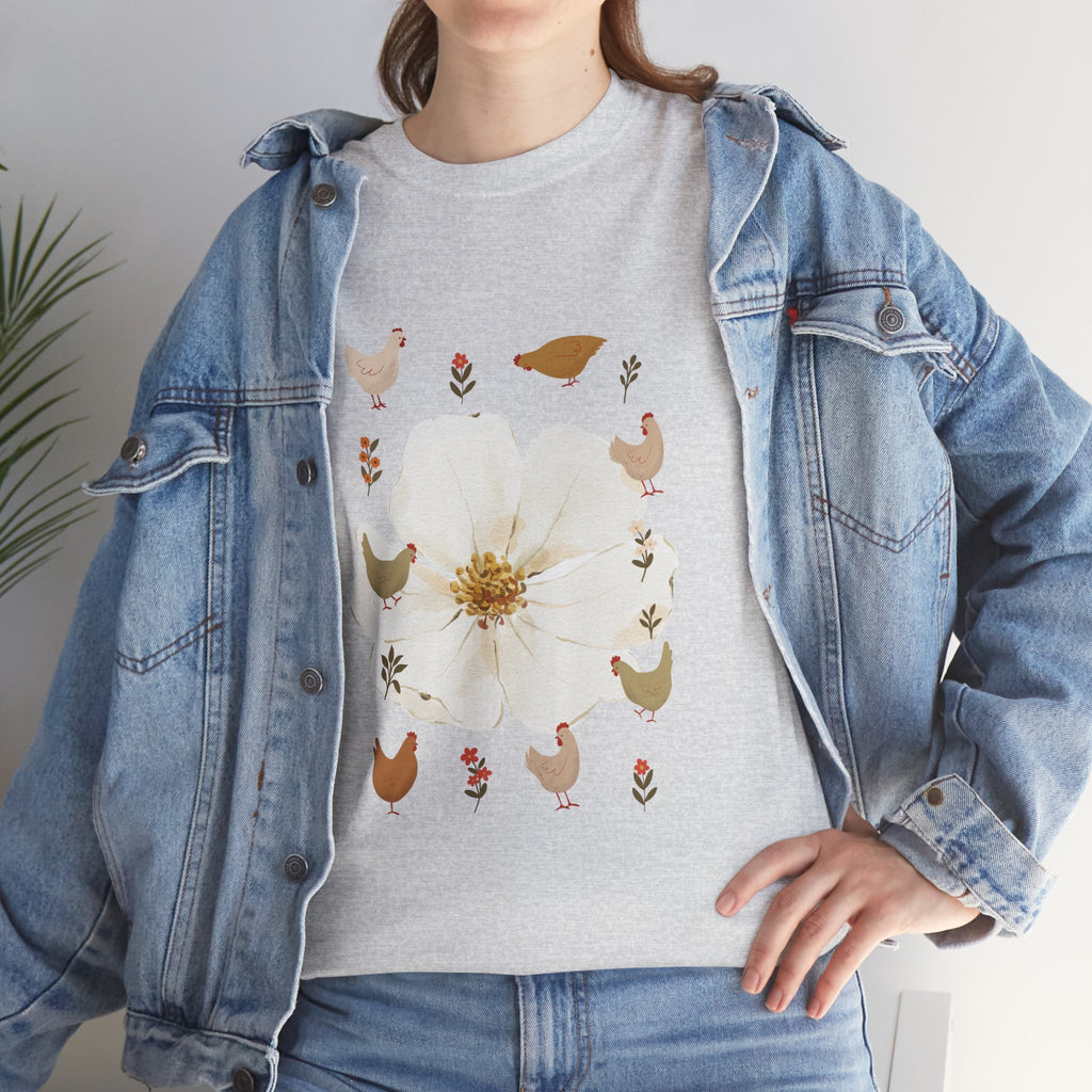 A girl wearing a denim jacket over a grey t-shirt featuring a colorful design of a bloom surrounded by roosters in various poses.