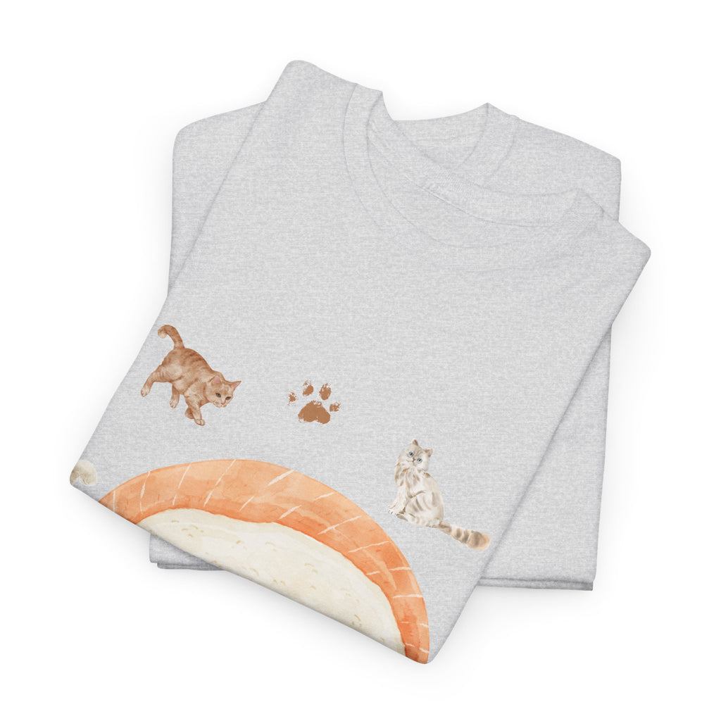 A folded grey t-shirt featuring a graphic design of a piece of nigiri sushi surrounded by a circle of cats, yarn balls, and cushions.