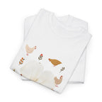 A folded white t-shirt featuring a graphic design of a bloom surrounded by roosters in various poses.