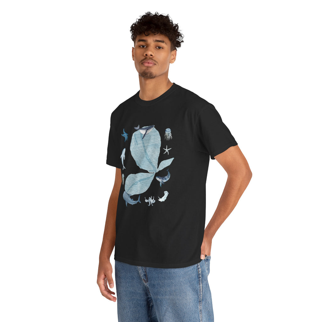 A man wearing a black t-shirt featuring a graphic design of a blue bloom surrounded by whales, jellyfish, and starfish.