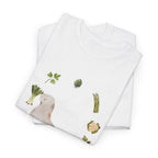 A folded white t-shirt featuring a graphic design of a sea lion surrounded by green onions, cabbage, and broccoli.
