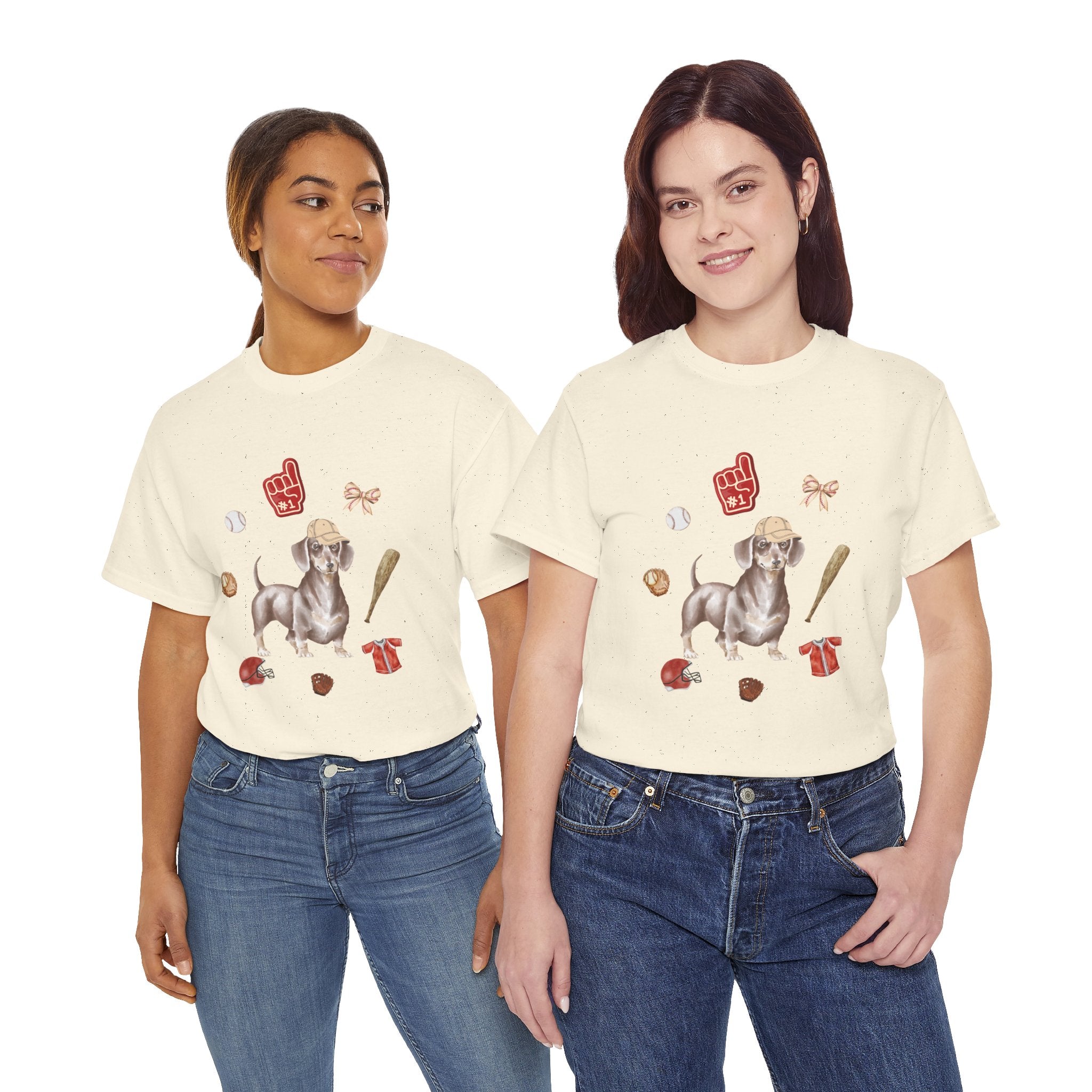 Two girls wearing beige t-shirts featuring a graphic design of a dog in a baseball hat surrounded by a circle of balls, bats, and helmets.