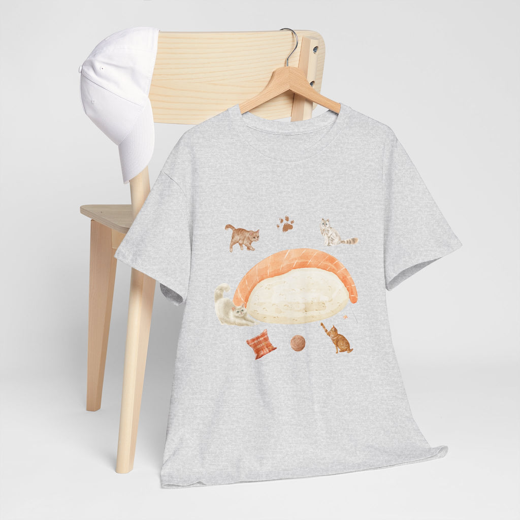A grey t-shirt hanging on a chair, featuring a graphic design of a piece of nigiri sushi surrounded by a circle of cats, yarn balls, and cushions.