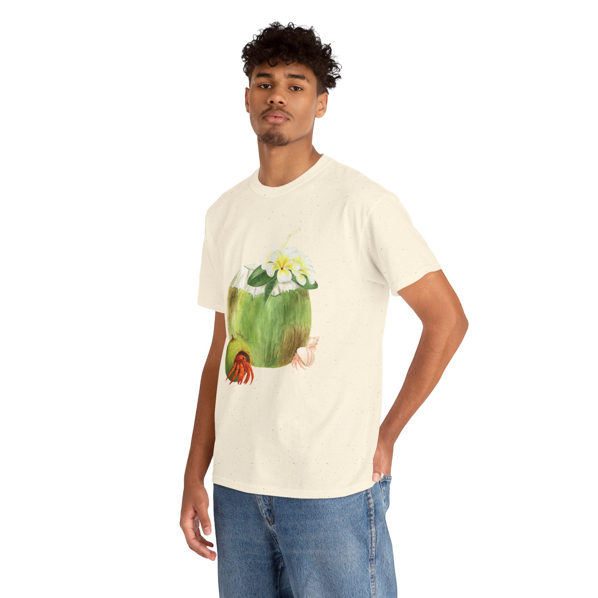 A man wearing a beige t-shirt featuring a graphic design of a hermit crab in a coconut shell and a straw-topped coconut.