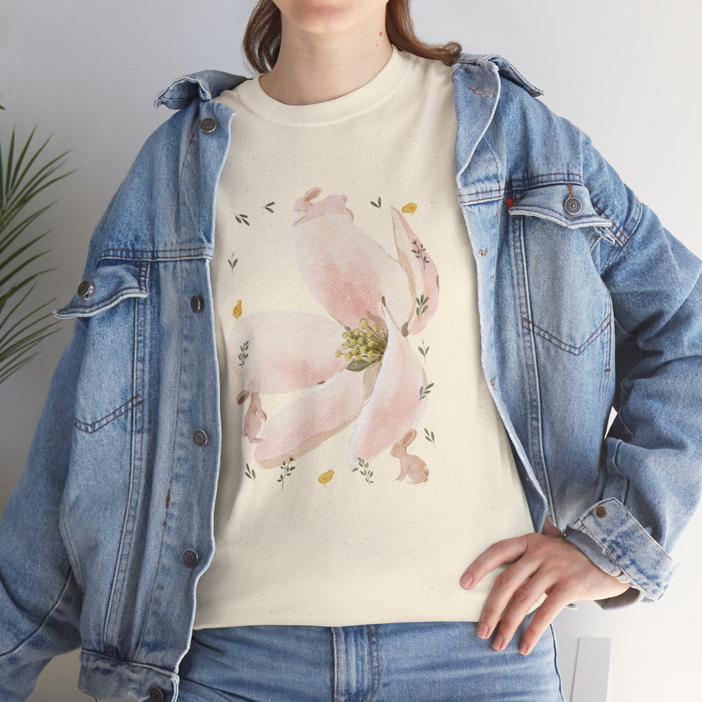 A girl wearing a denim jacket over a beige t-shirt featuring a colorful design of a pink bloom surrounded by bunnies in various poses.