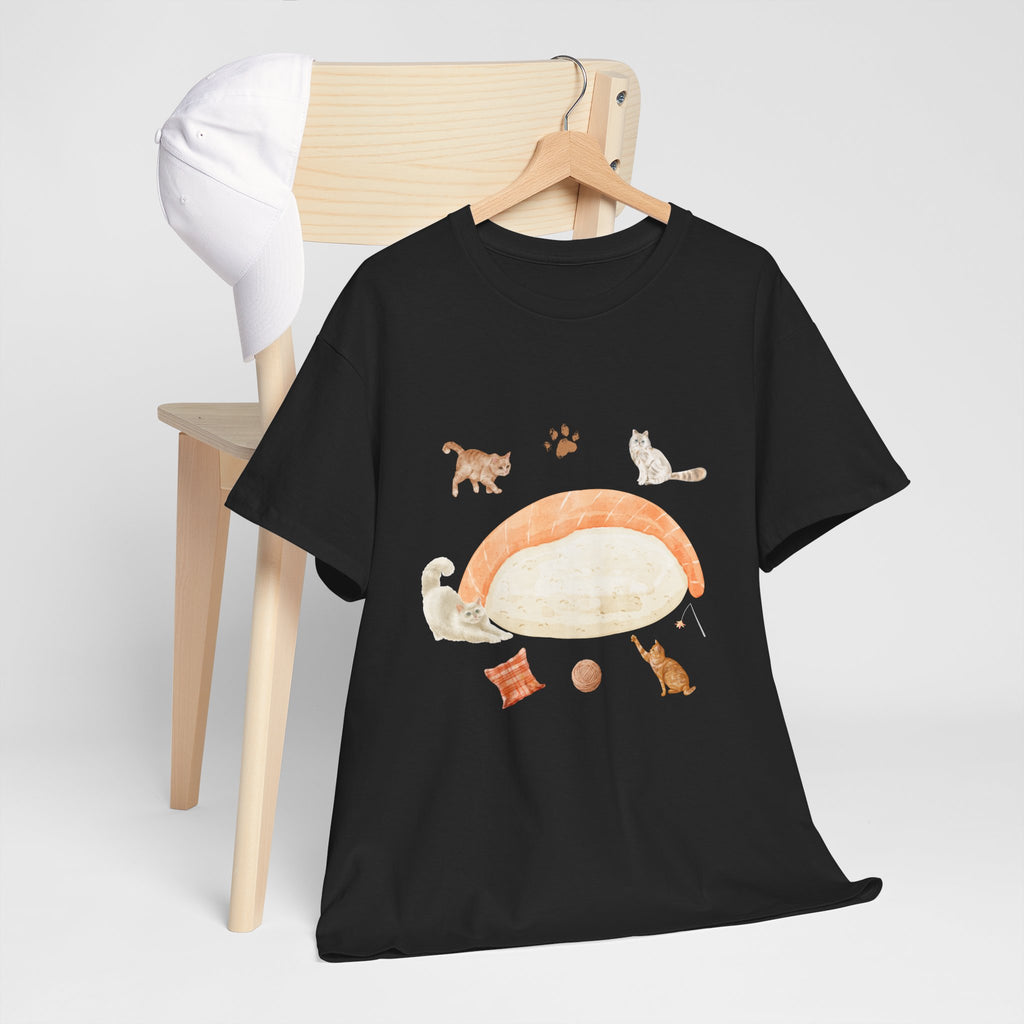 A black t-shirt hanging on a chair, featuring a graphic design of a piece of nigiri sushi surrounded by a circle of cats, yarn balls, and cushions.