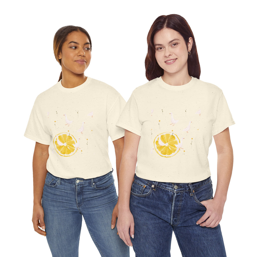 Two girls wearing beige t-shirts featuring a graphic design of white ducks filling the frame and a juicy lemon in the bottom-left corner.