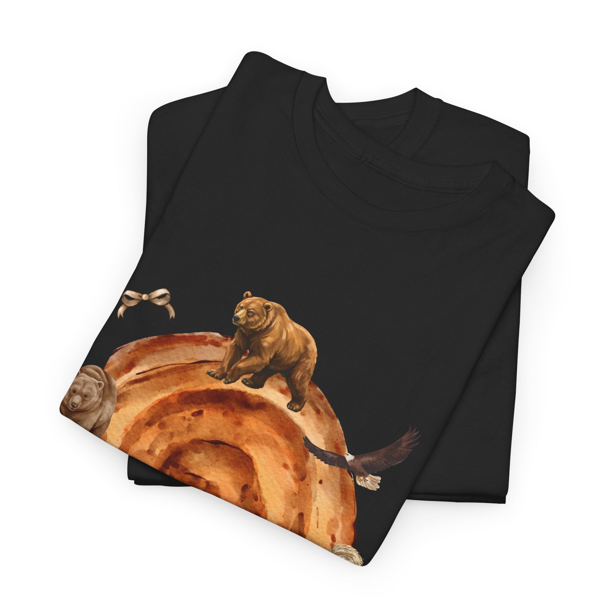 A folded black t-shirt featuring a graphic design of a cinnamon roll surrounded by several hungry bears.