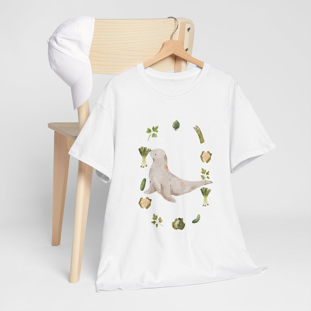 A white t-shirt hanging on a chair, featuring a graphic design of a sea lion surrounded by green onions, cabbage, and broccoli.
