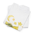 A folded white t-shirt featuring a graphic design of a tree stump, leaves, and starfruit celestial elements.