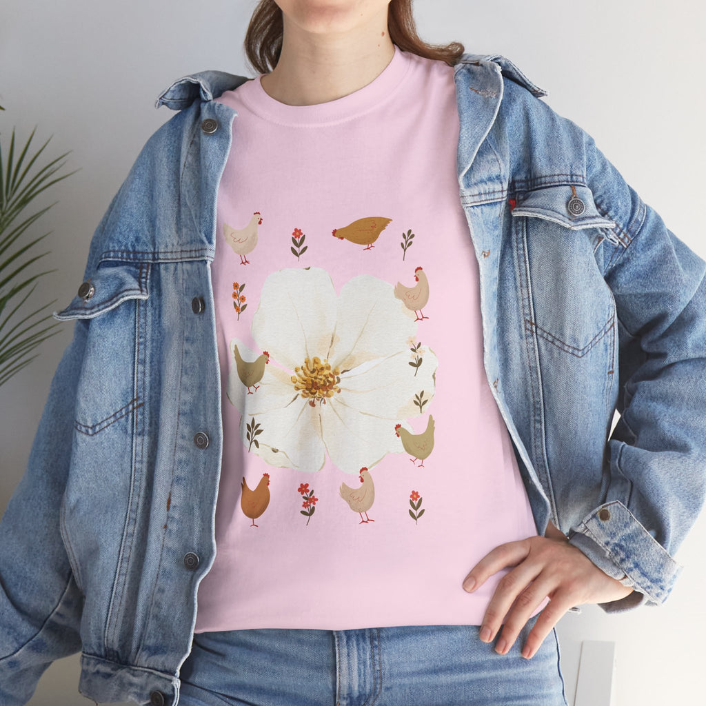 A girl wearing a denim jacket over a pink t-shirt featuring a colorful design of a bloom surrounded by roosters in various poses.