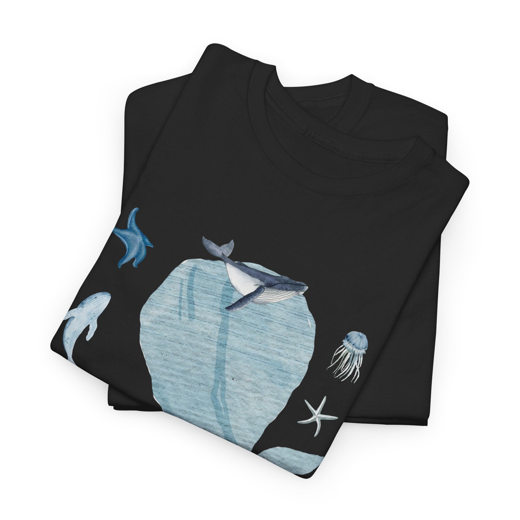A folded black t-shirt featuring a graphic design of a blue bloom surrounded by whales, jellyfish, and starfish.