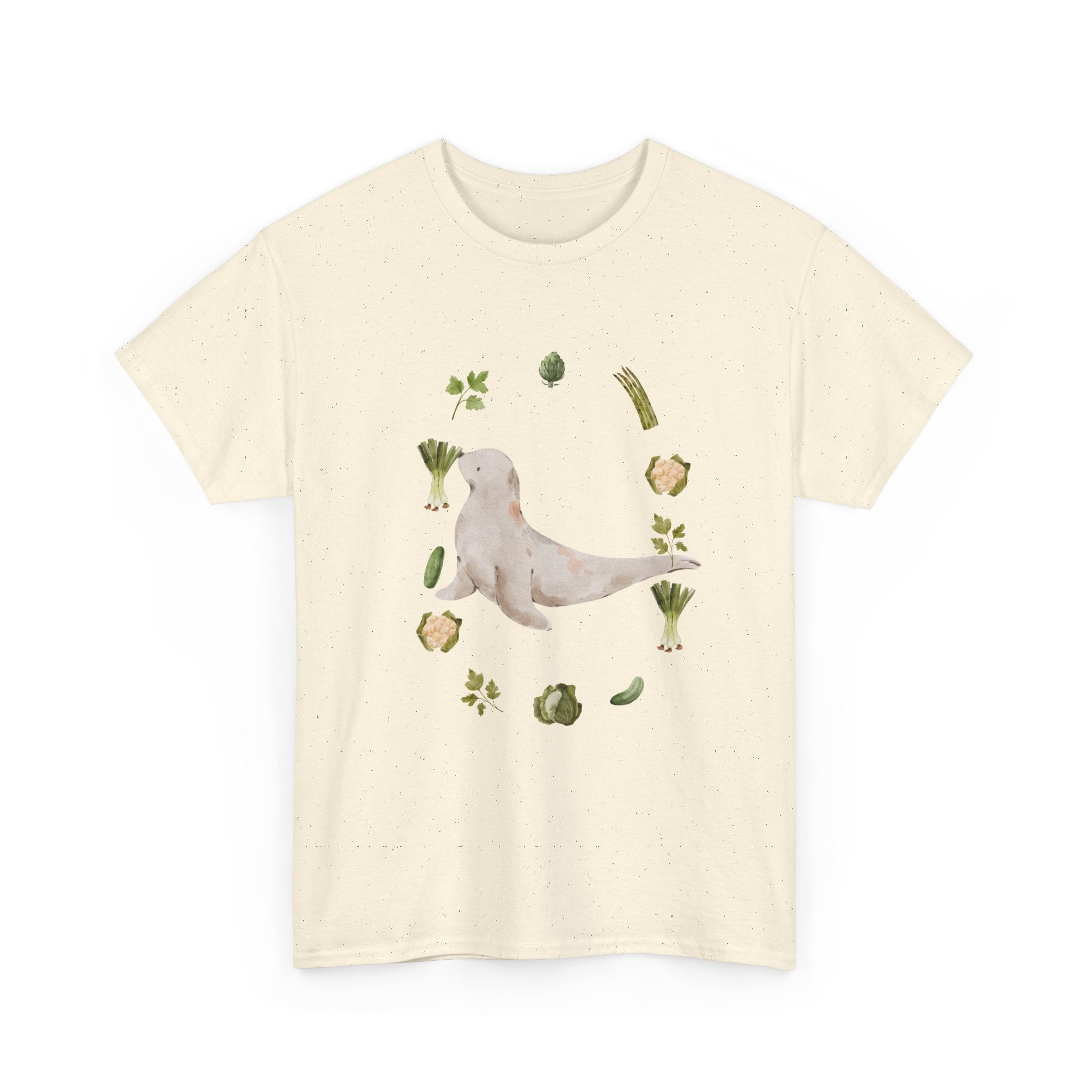 Beige t-shirt with a sea lion surrounded by green onions, cabbage, and broccoli.