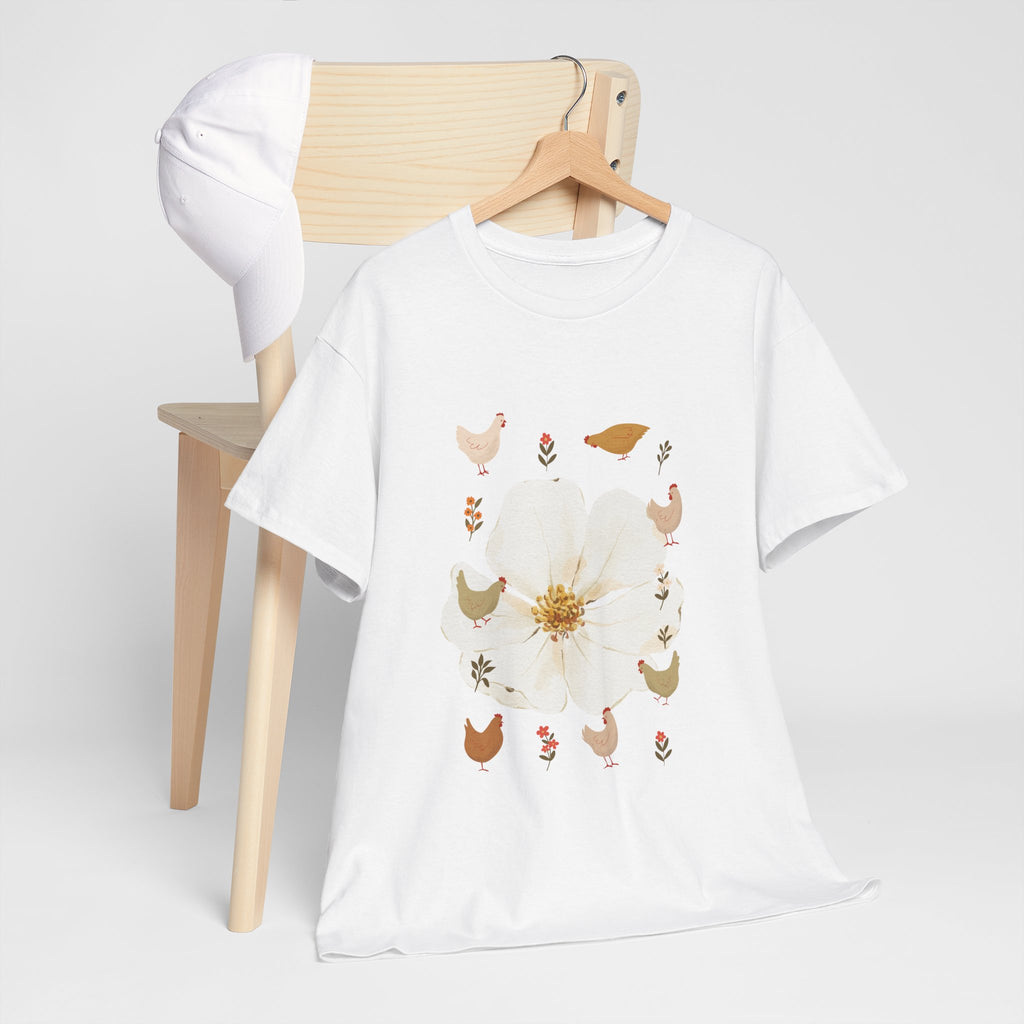 A white t-shirt hanging on a chair, featuring a graphic design of a bloom surrounded by roosters in various poses.
