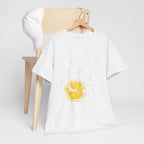 A white t-shirt hanging on a chair, featuring a graphic design of white ducks across the whole shirt and a juicy lemon in the bottom-left corner.