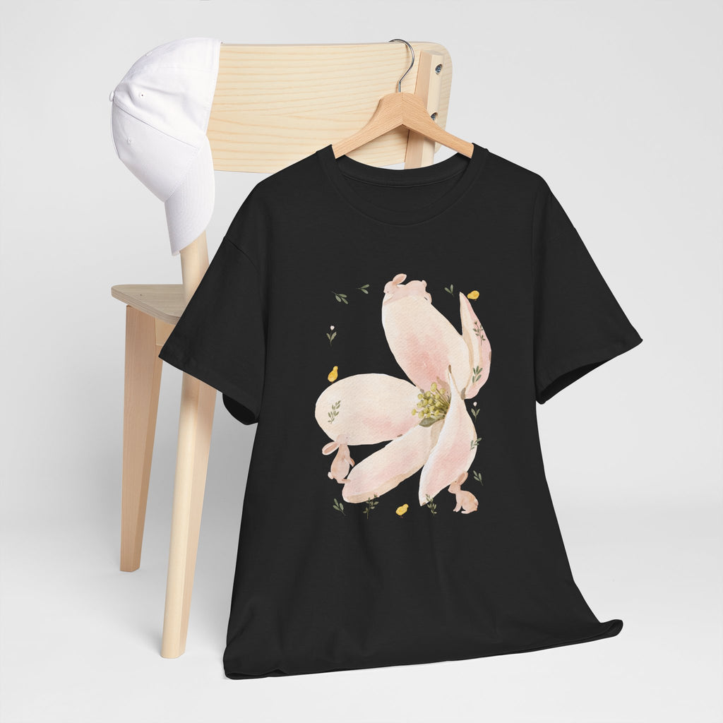 A black t-shirt hanging on a chair, featuring a graphic design of a pink bloom surrounded by bunnies in various poses.