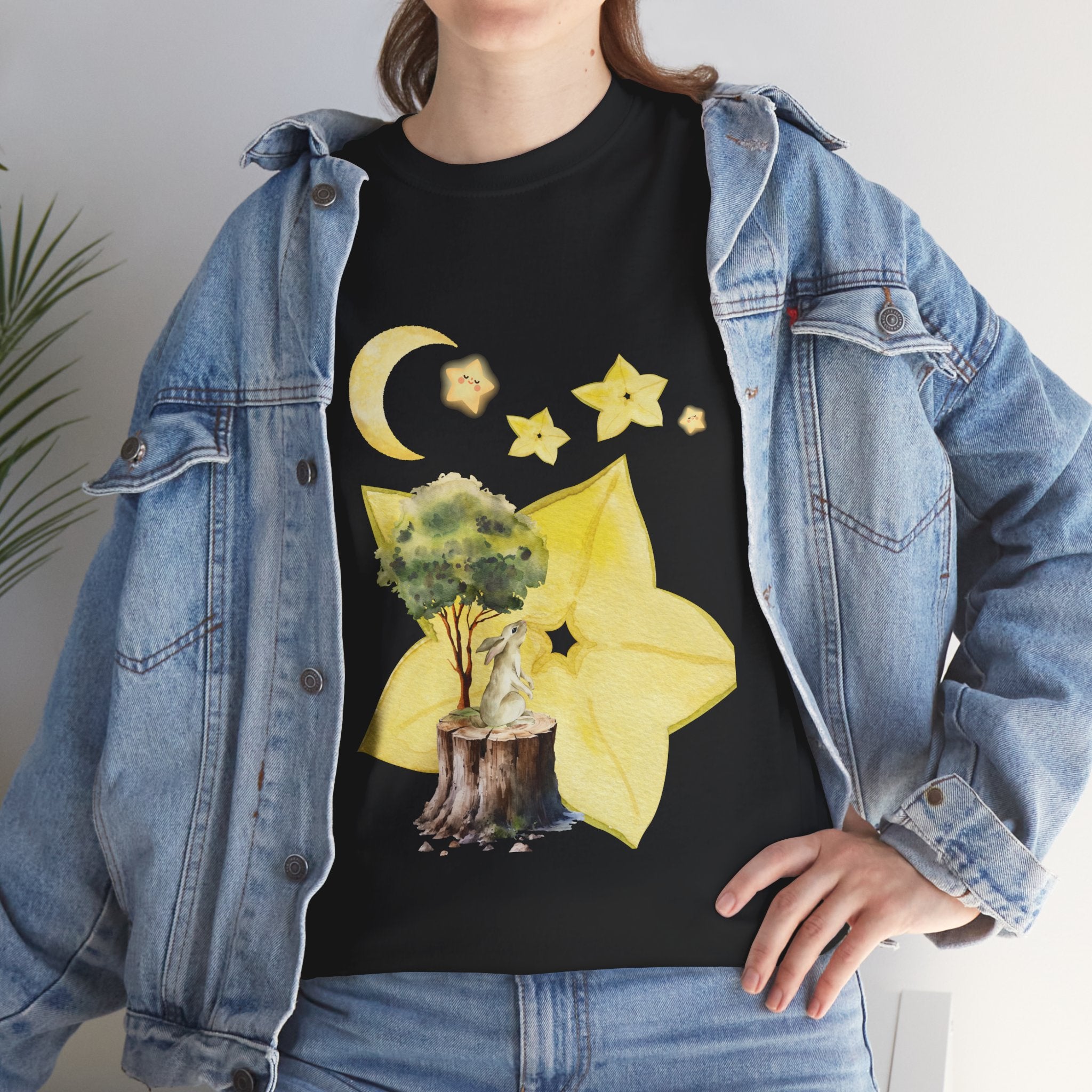 A girl wearing a denim jacket over a black t-shirt featuring a colorful design of a tree, moon, and starfruit celestial elements.