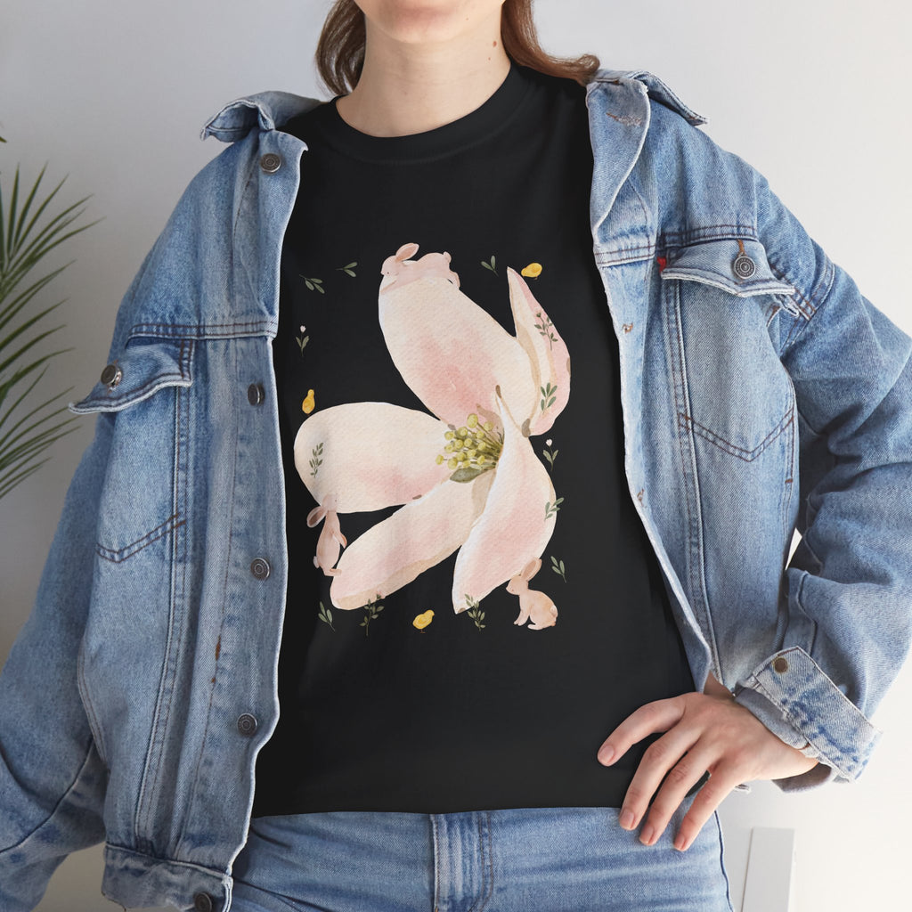A girl wearing a denim jacket over a black t-shirt featuring a colorful design of a pink bloom surrounded by bunnies in various poses.