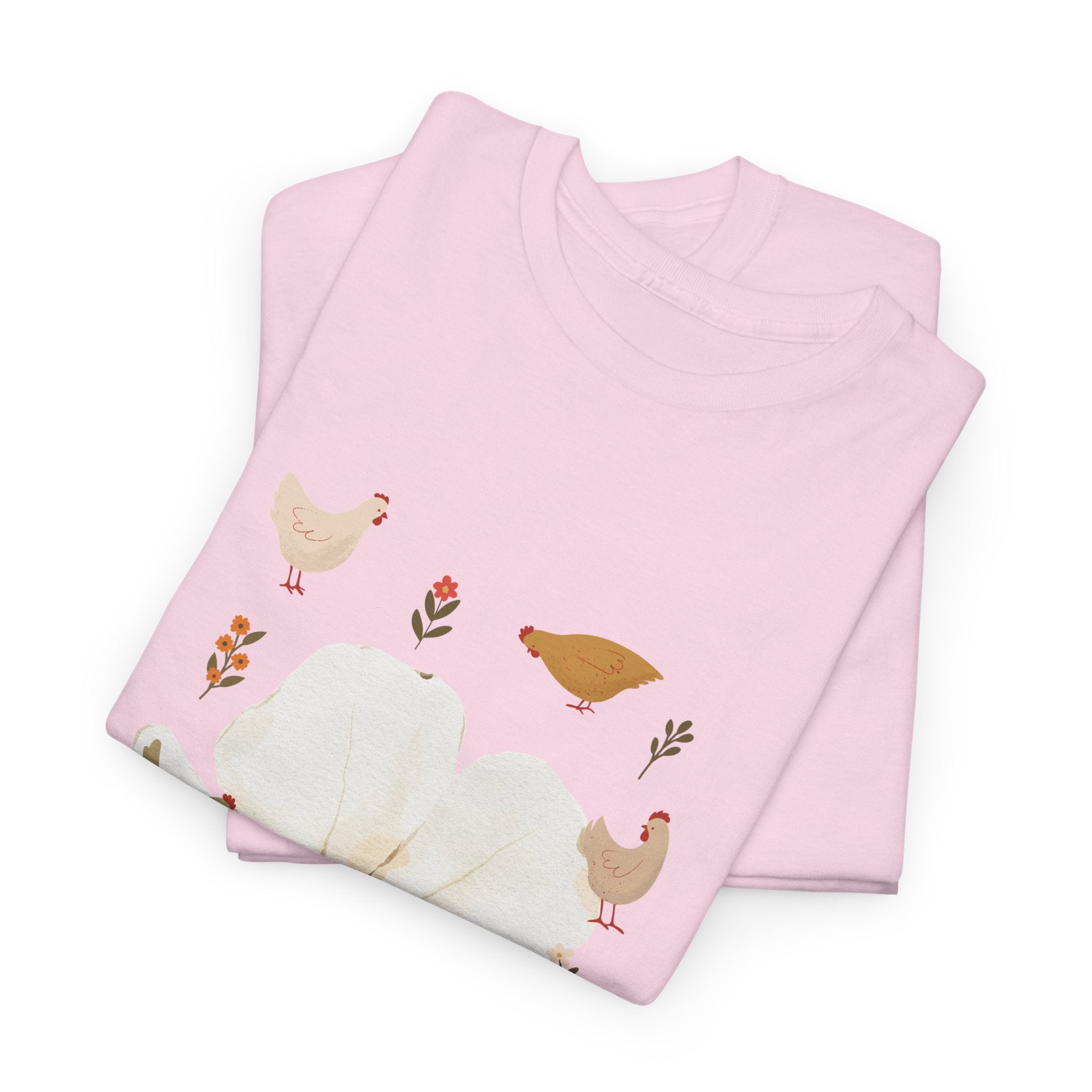 A folded pink t-shirt featuring a graphic design of a bloom surrounded by roosters in various poses.