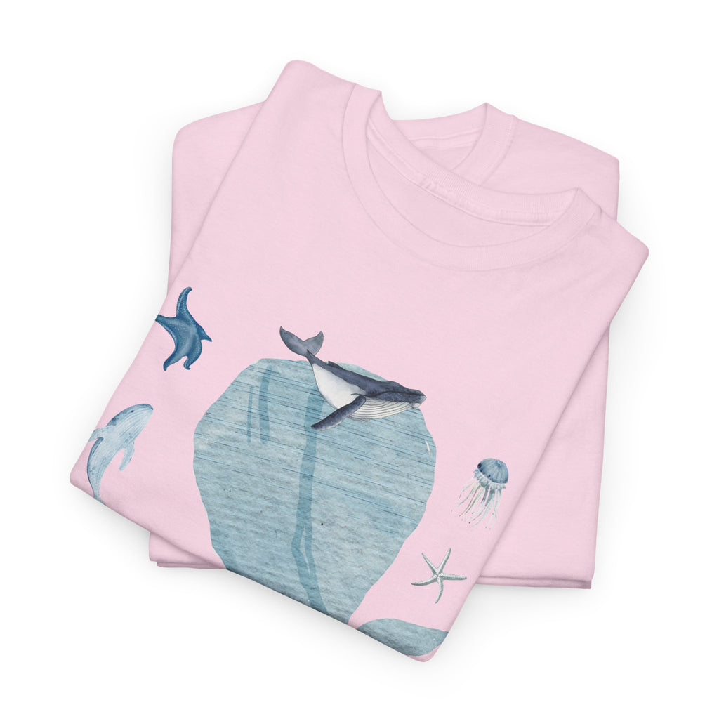 A folded pink t-shirt featuring a graphic design of a blue bloom surrounded by whales, jellyfish, and starfish.