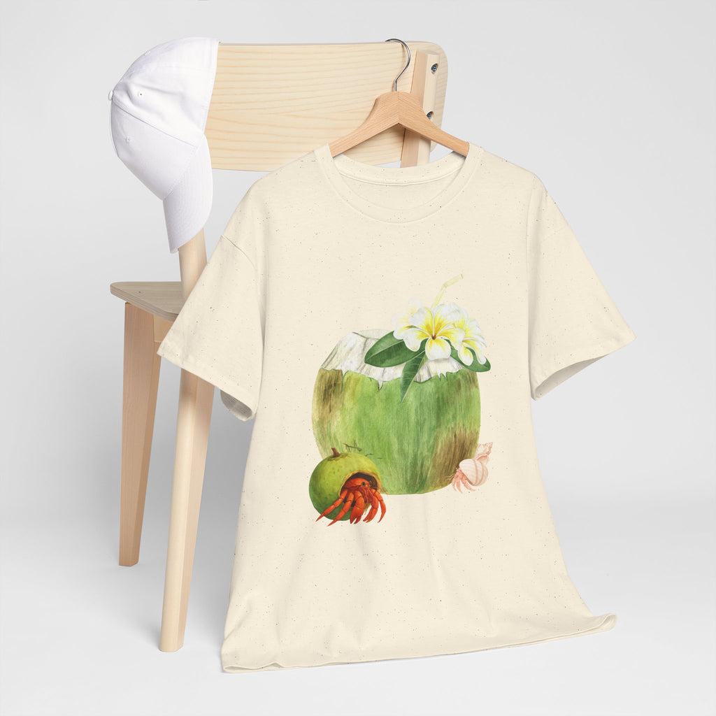 A beige t-shirt hanging on a chair, featuring a graphic design of a hermit crab in a coconut shell and a straw-topped coconut.