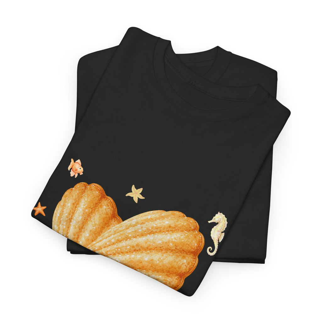 A folded black t-shirt featuring a graphic design of a heart-shaped madeleine surrounded by yellow tropical fish, starfish, seahorses, and coral.