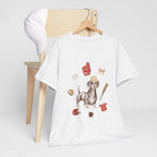 A white t-shirt hanging on a chair, featuring a graphic design of a dog in a baseball hat surrounded by a circle of balls, bats, and helmets.