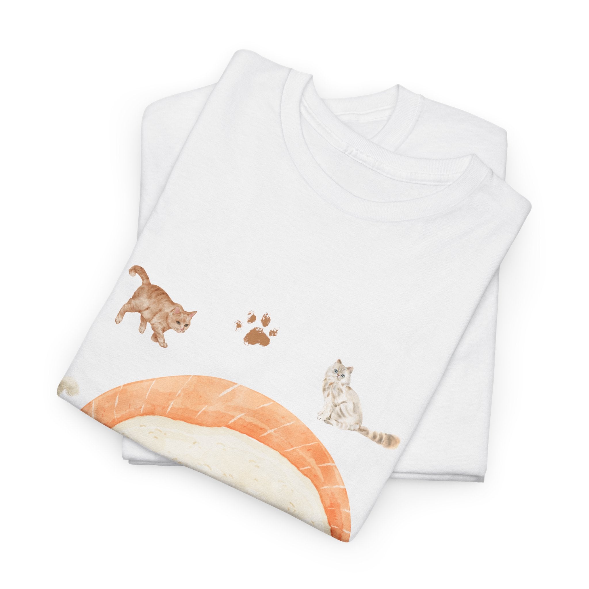 A folded white t-shirt featuring a graphic design of a piece of nigiri sushi surrounded by a circle of cats, yarn balls, and cushions.